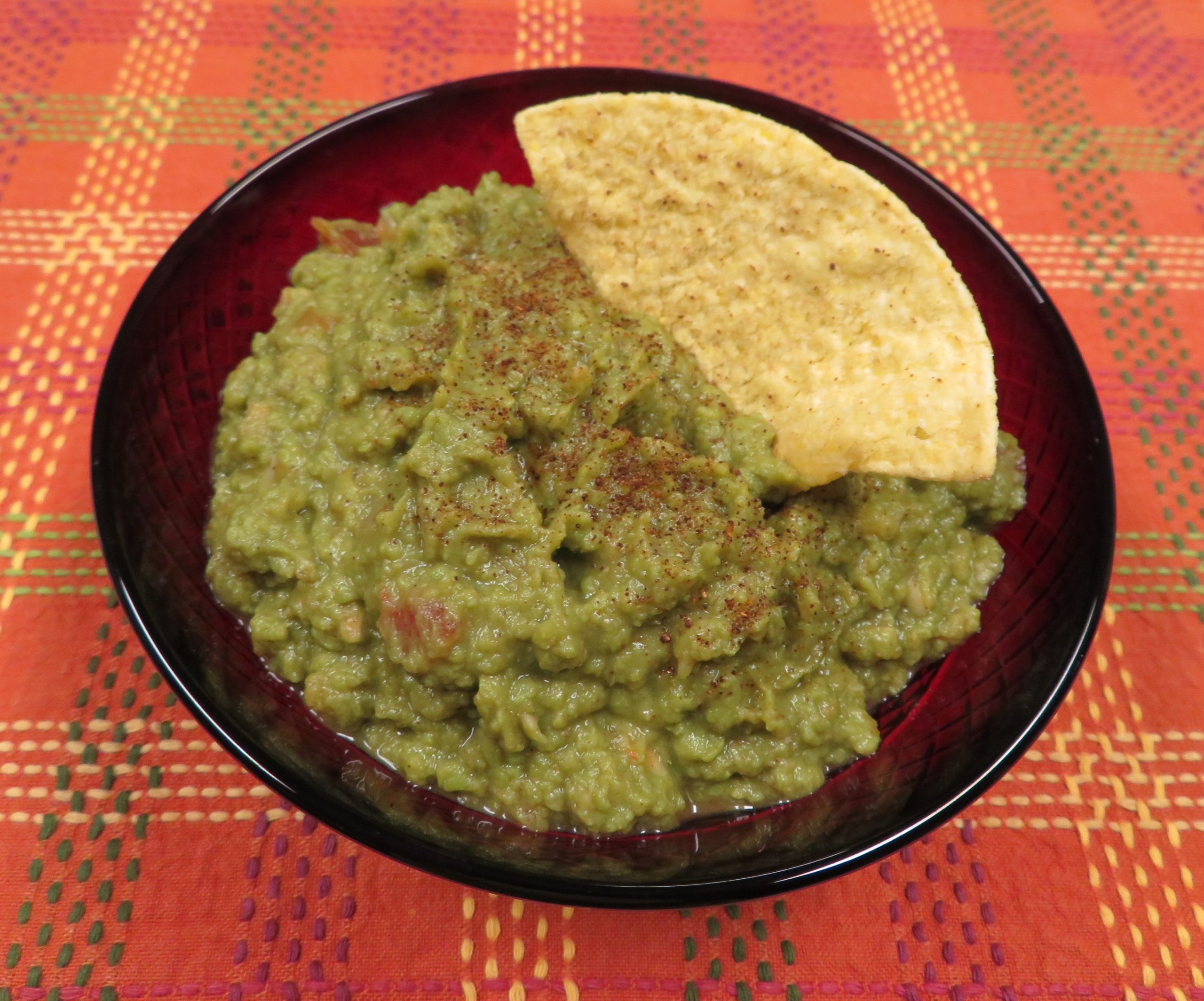 A bowl of Pantry Guacamole with a tortilla chip in it