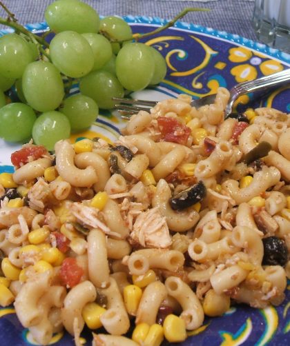 Amazing Tex-Mex Pasta Salad on a blue patterned plate with grapes