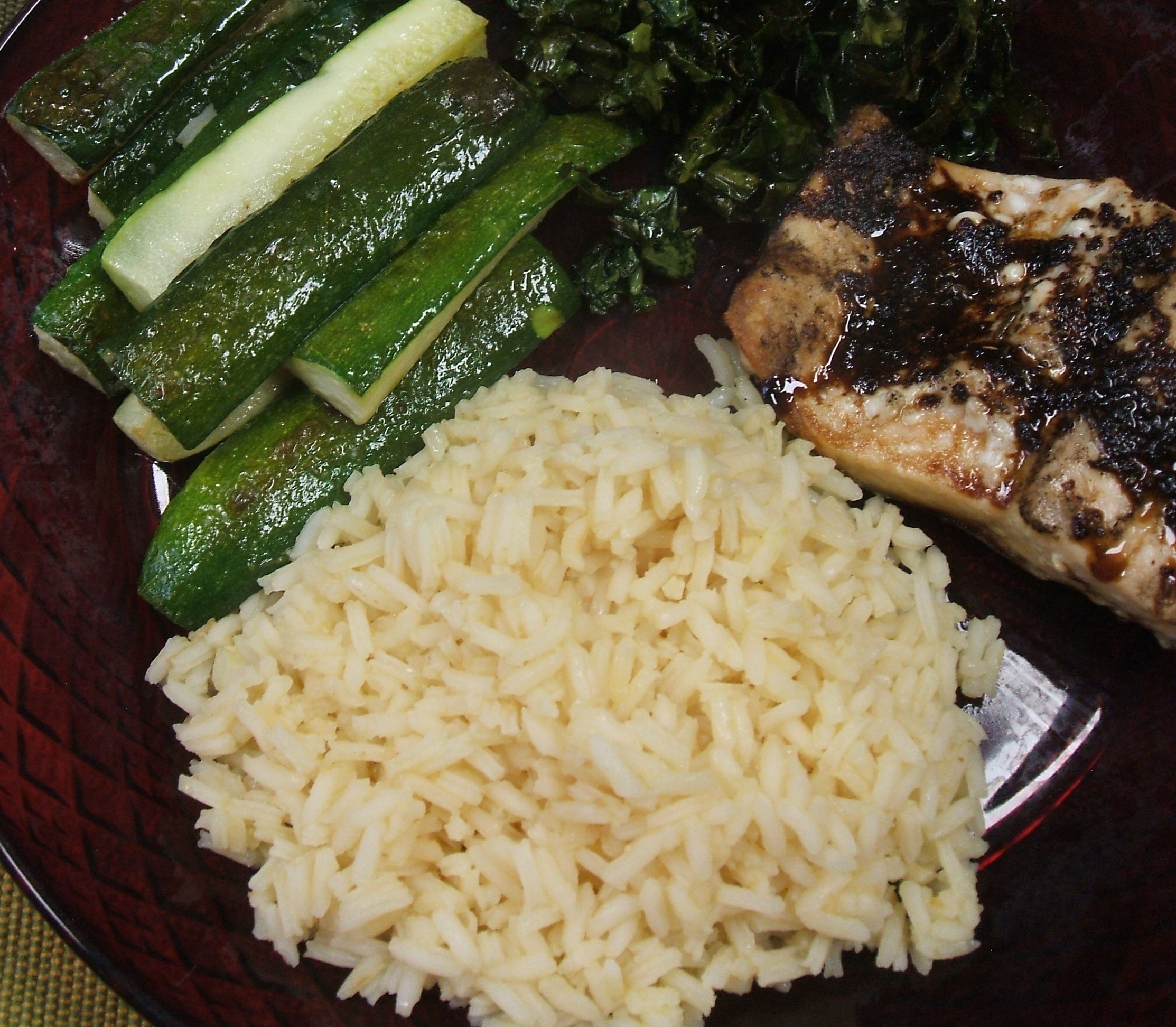 Orange rice on a plate with vegetables and meat