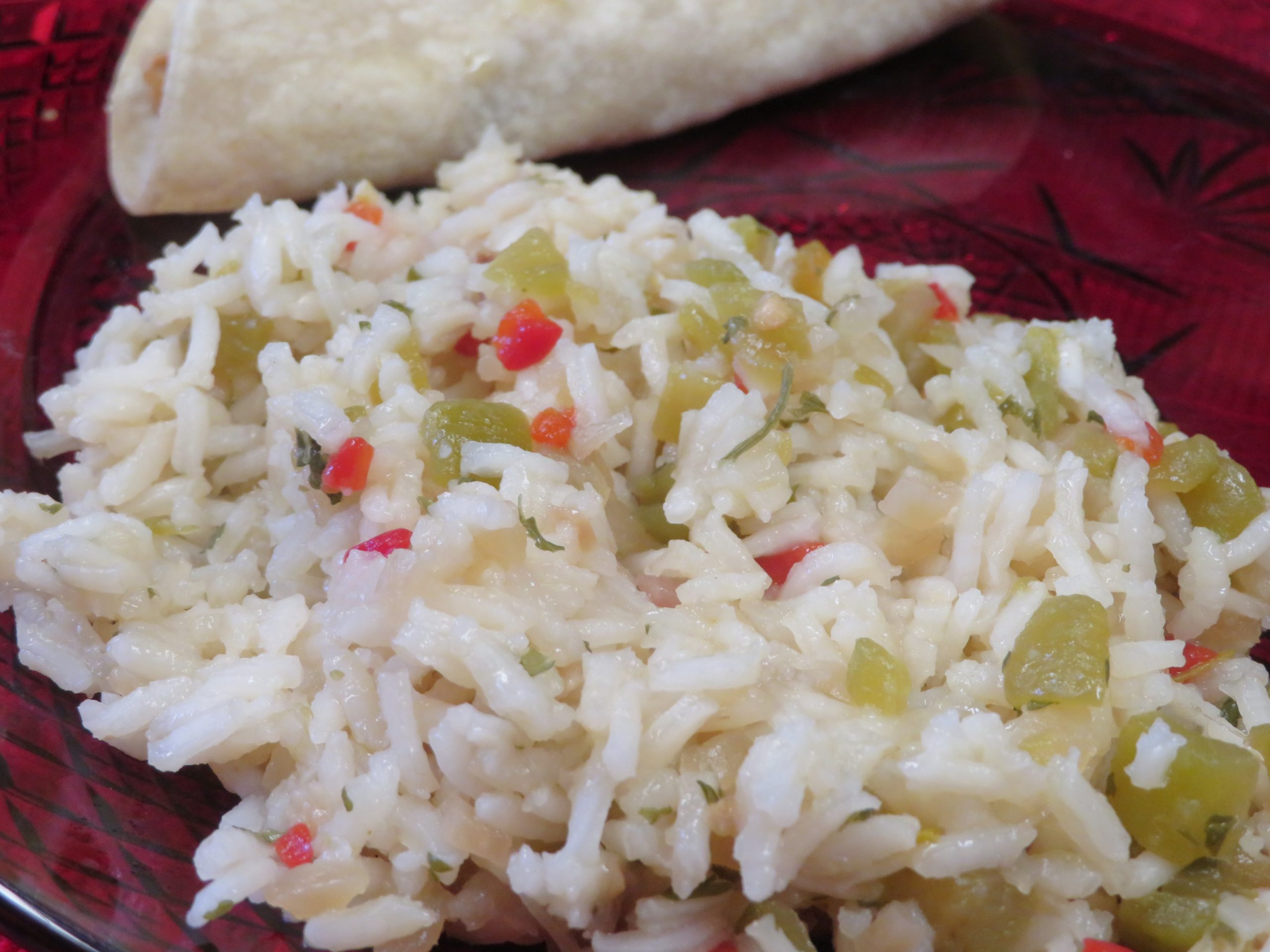 Green chile rice on a red plate