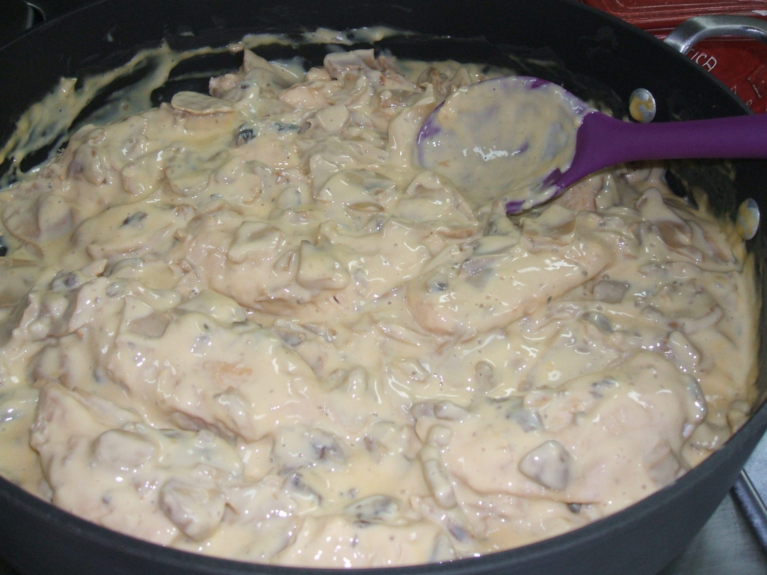 A skillet of chicken in mushroom cheese sauce