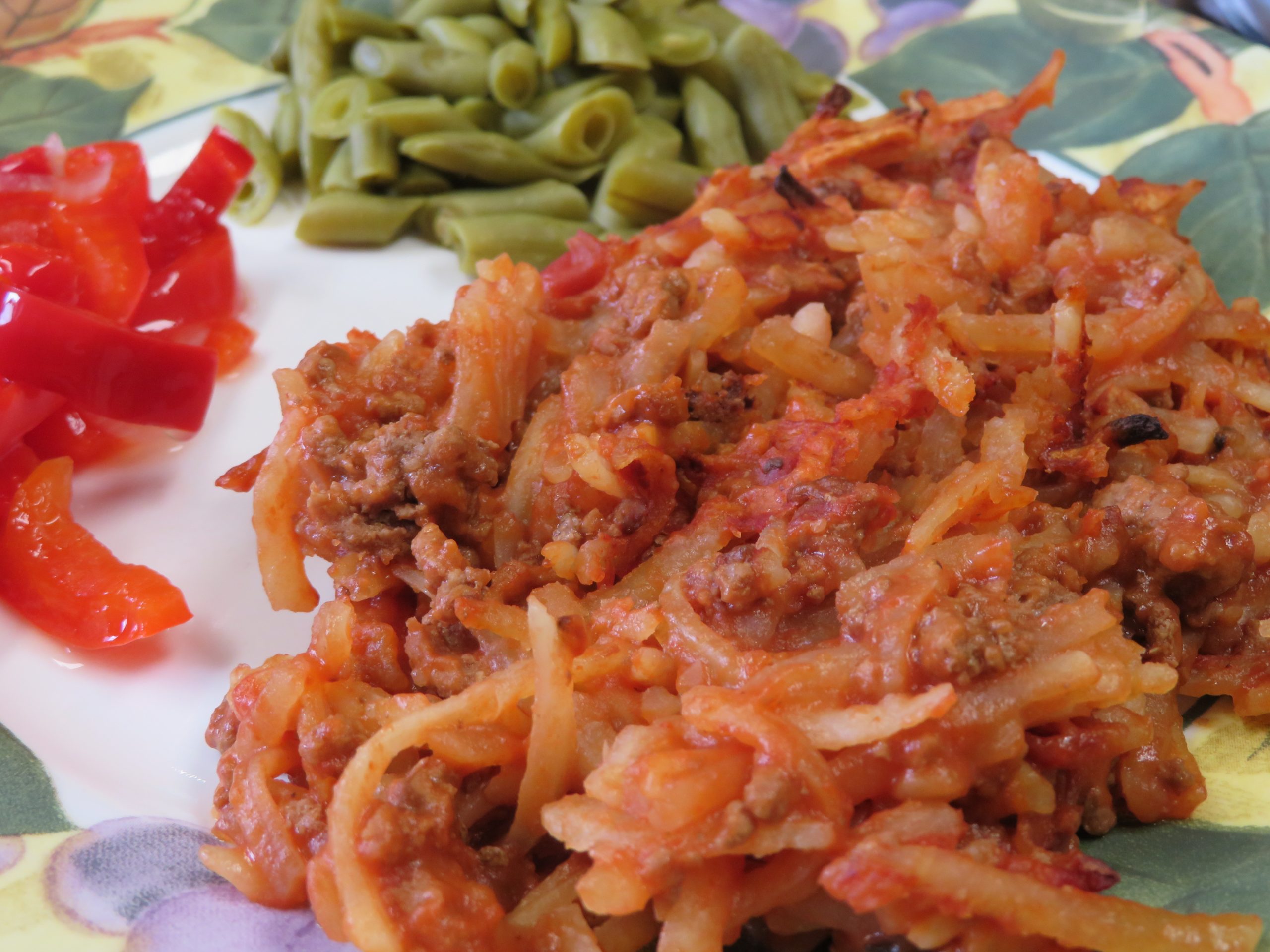 Hamburger Hashbrown Casserole on a plate with vegetables