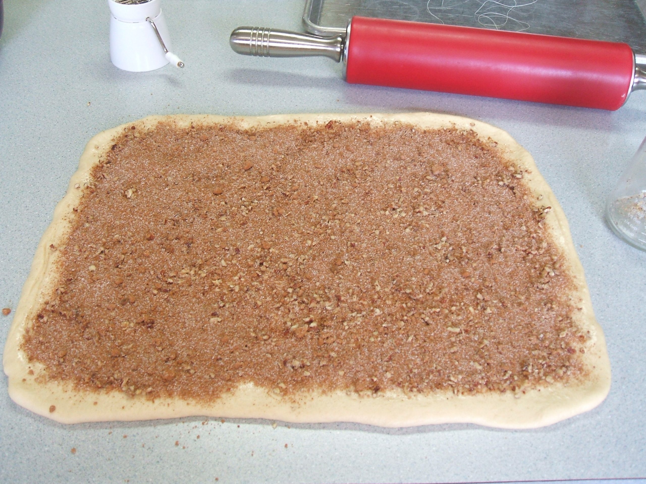 Cinnamon brown sugar spread on dough for cinnamon rolls