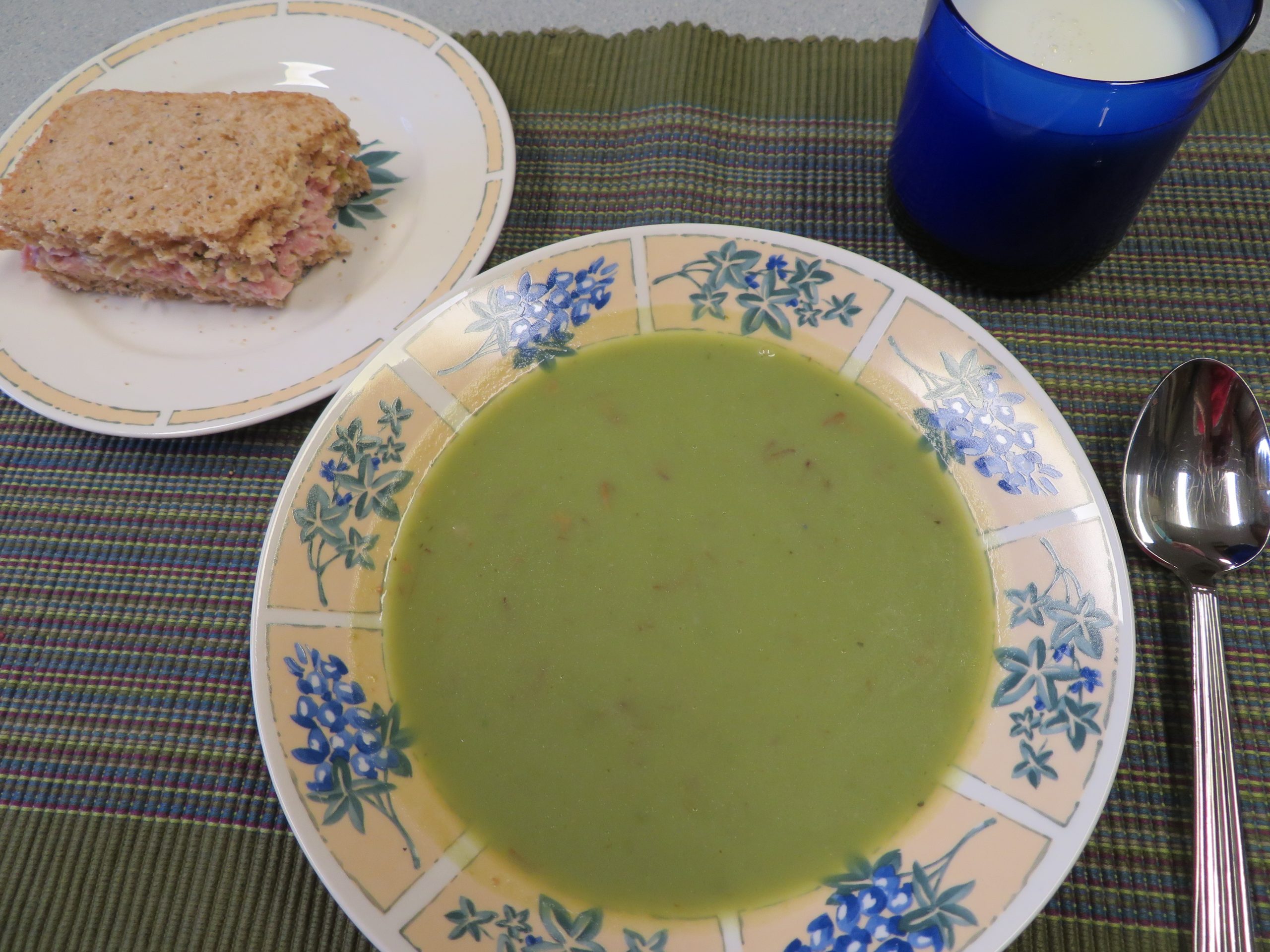 A bowl of Green Pea Soup, a Spam Salad sandwich on homemade bread, and a glass of milk