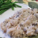 Creamy chicken and mushroom rice on a plate with fresh cooked green beans