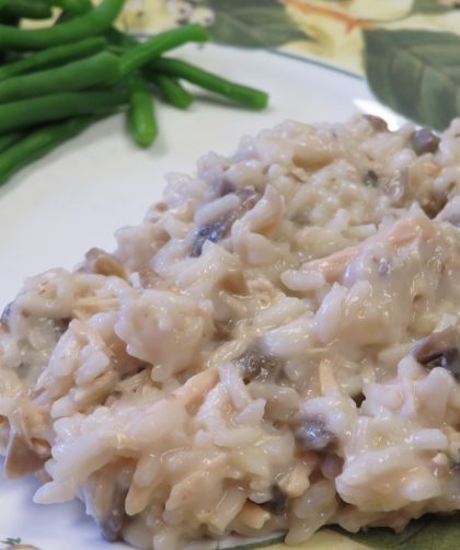 Creamy chicken and mushroom rice on a plate with fresh cooked green beans