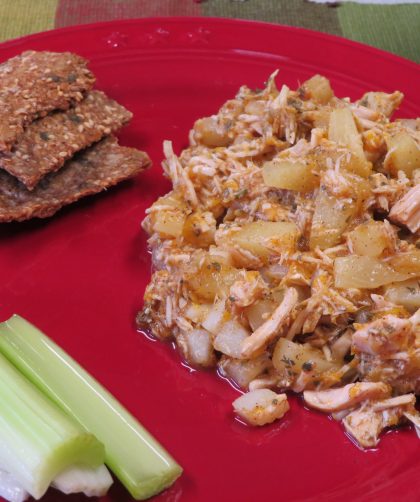 Tropical Pineapple Chicken Salad on a red plate with celery and crisp bread