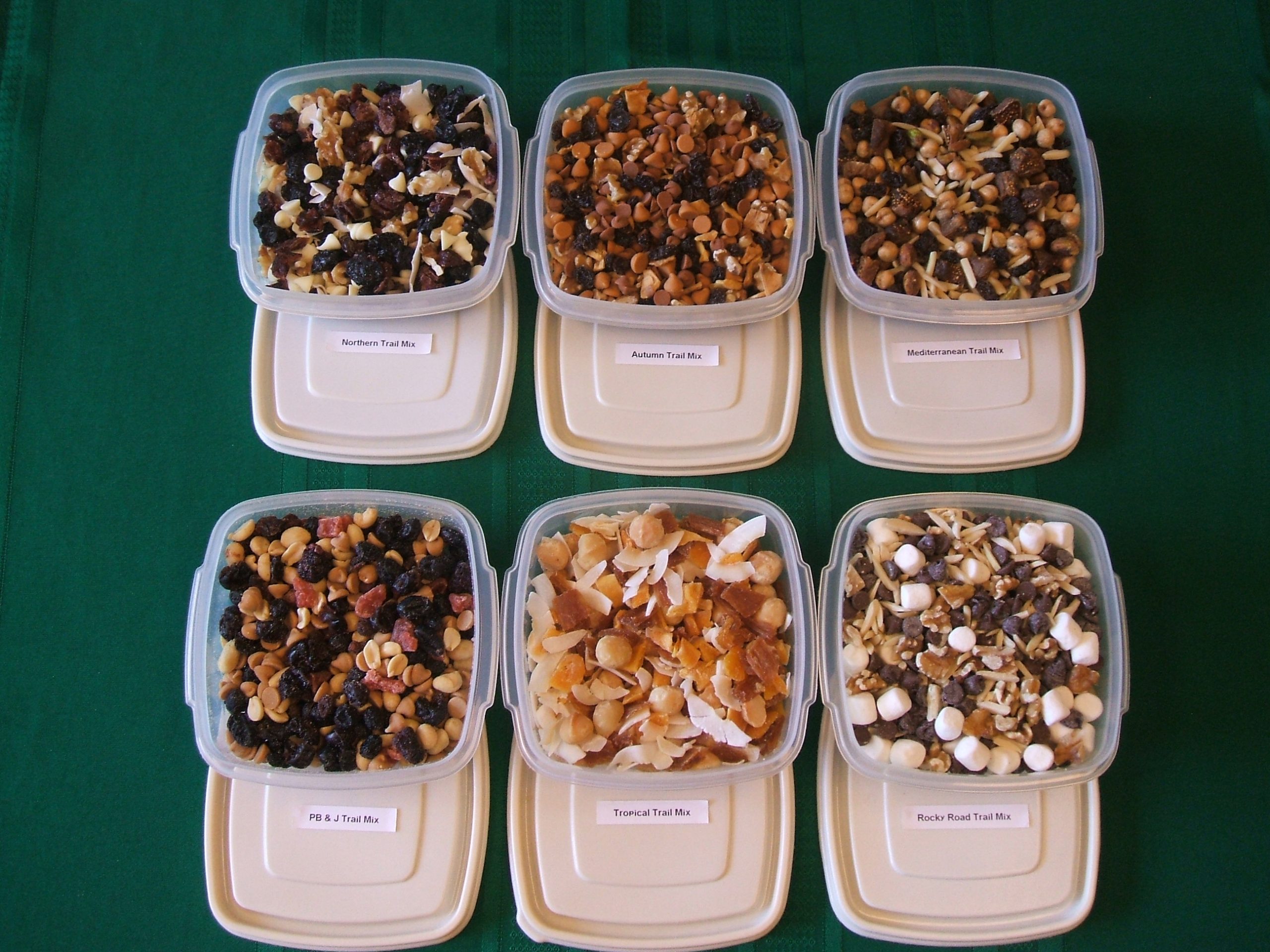 Six trail mixes in labeled plastic containers