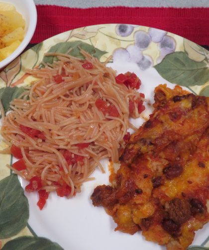 Dinner plate with Pantry Fideo and enchiladas, glass of milk, bowl of pineapple