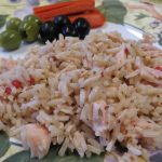 Herbed Rice and Chicken Salad on a plate with olives and red peppers