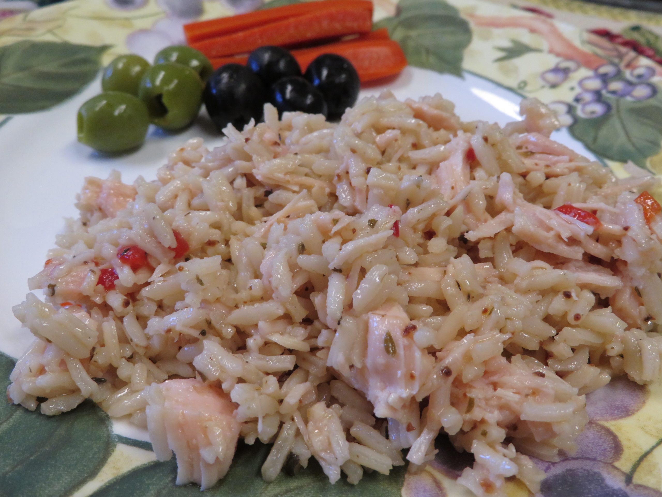 Herbed Rice and Chicken Salad on a plate with olives and red peppers