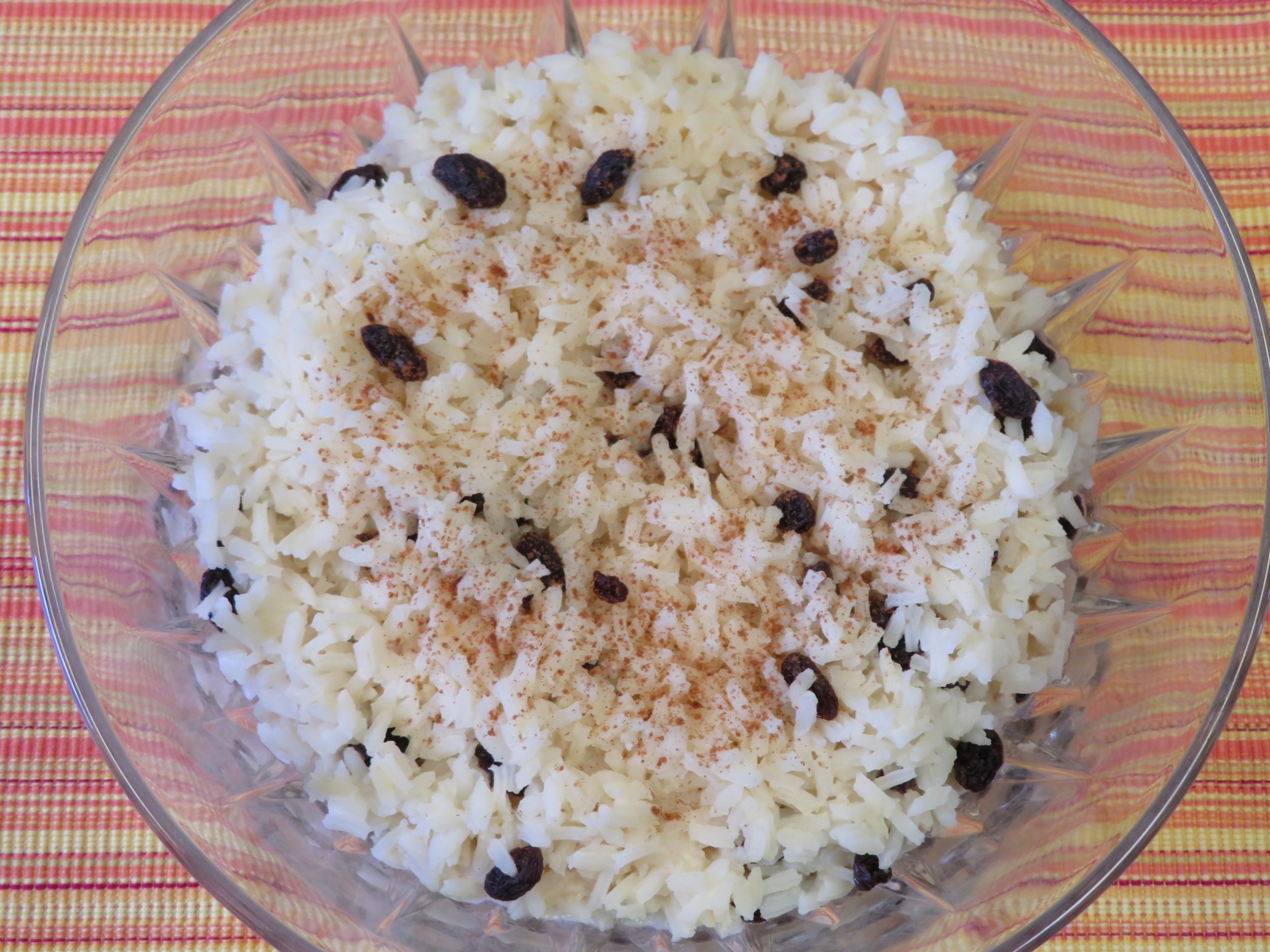 Quick Rice Pudding with raisins topped with cinnamon in a cut glass bowl