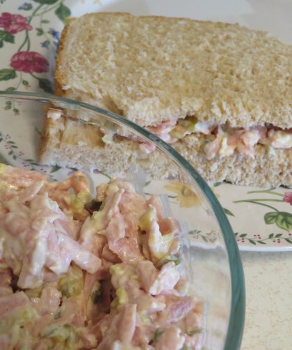 Dill Spam Salad in a glass bowl and a sandwich on a floral edged plate