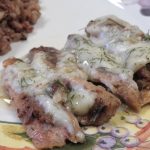 Baked Sardines with Dill Sauce on a plate with whole grain rice