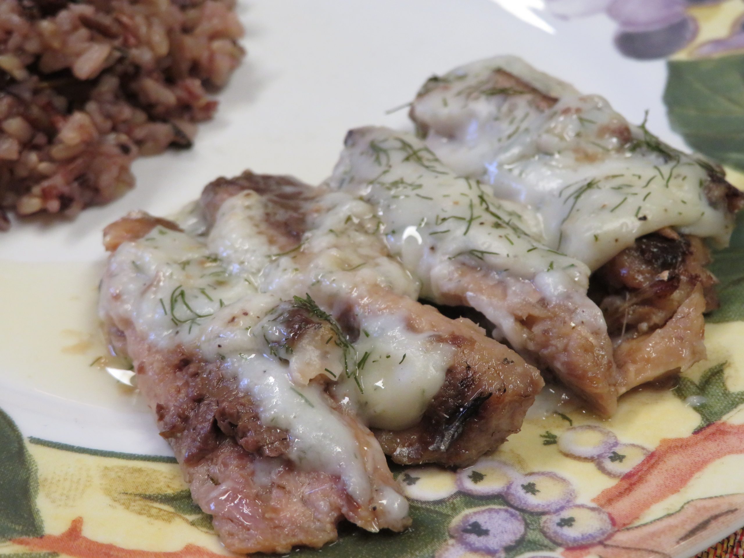 Baked Sardines with Dill Sauce on a plate with whole grain rice