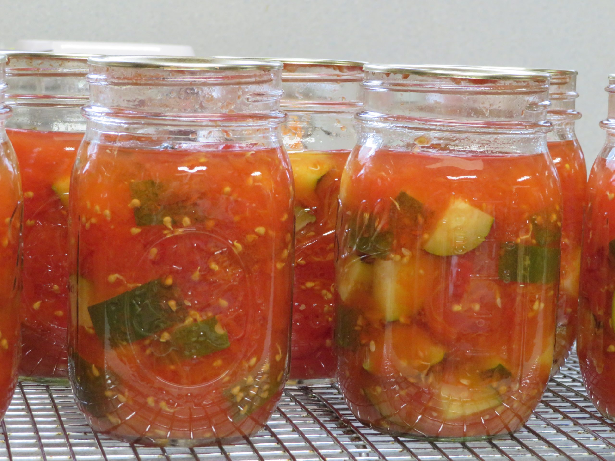 Pint jars of home canned tomatoes and zucchini