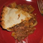 A slice of Beef and Mushroom Pie on a red plate