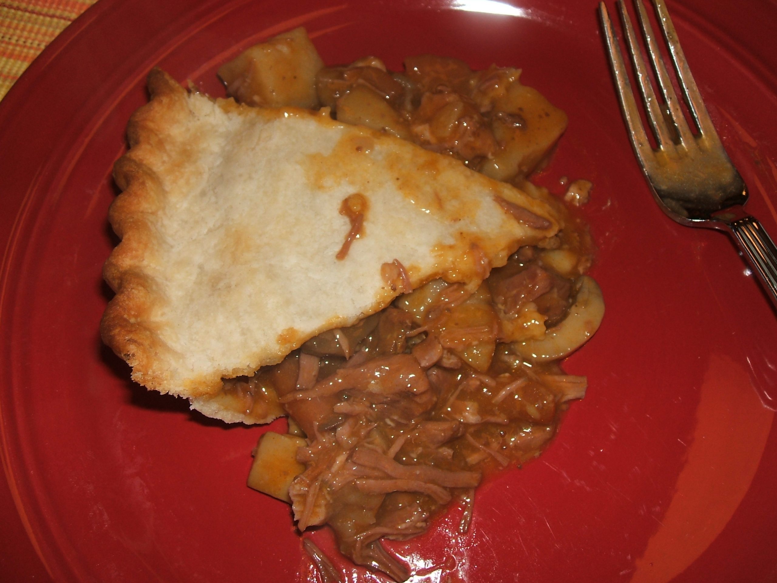 A slice of Beef and Mushroom Pie on a red plate